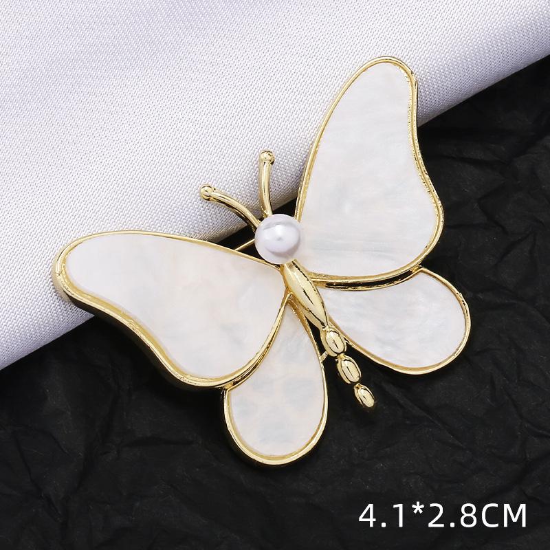 Módní brož s lukem: Kovové šperky s perlou a kamínkovou květinou