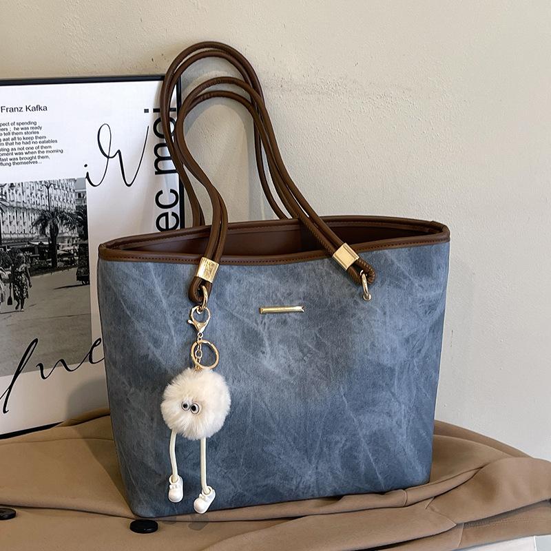 Tato velkokapacitní taška tote s minimalistickým designem je všestranná taška přes jedno rameno pro dojíždění.