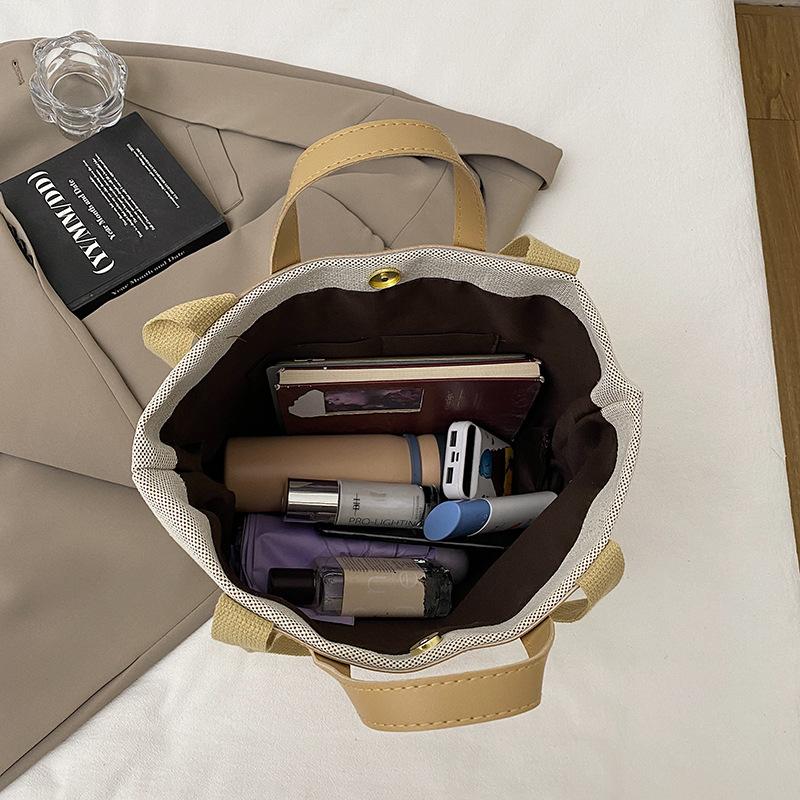 Fritid och konst splicing canvas 2025 vävning enkel ny temperament pendling mode tote bärbar axelväska