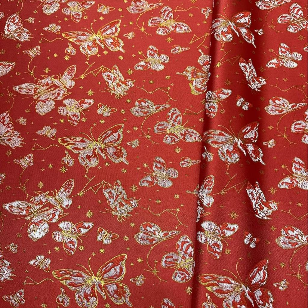 Ethnischer Jacquardstoff für Damen- und Kinderbekleidung in Rosa, Lila, Rot und Gold.