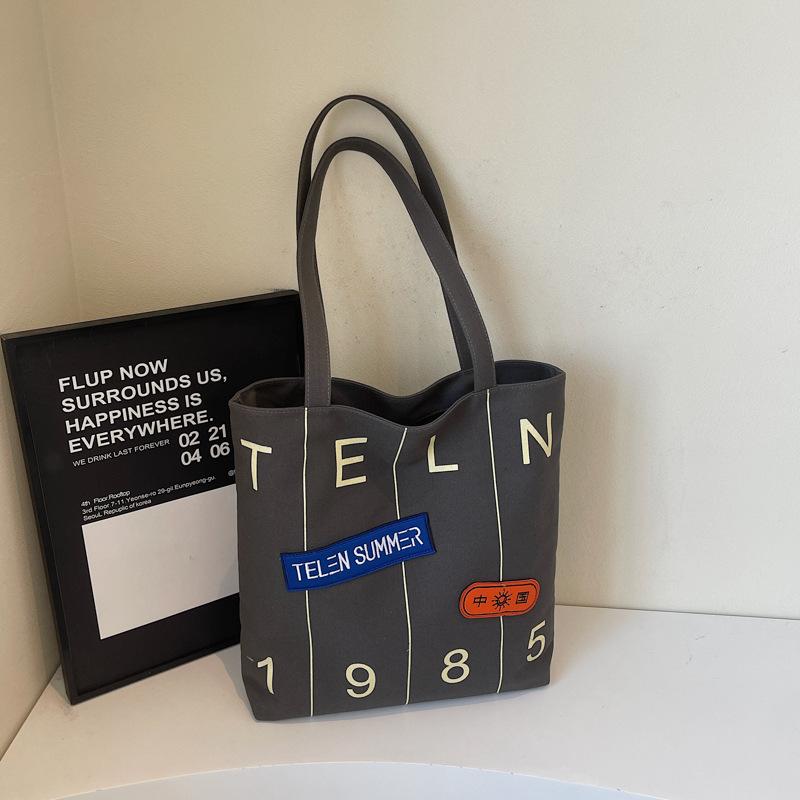 

Large capacity alphabet canvas bag female 2025 new student class tote bag fashionable shoulder commuter tote bag