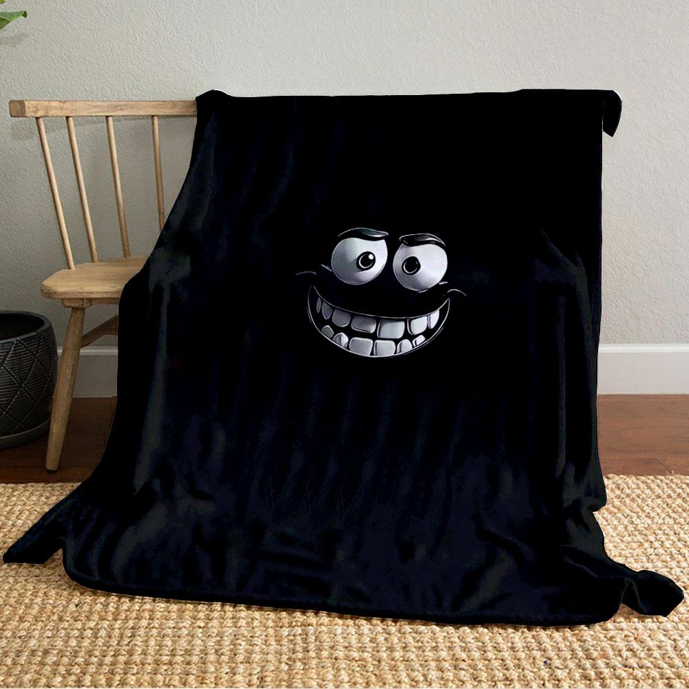 A glowing, cartoonish face with wide eyes and a big toothy grin on black. for all seasons blanket lunch break throw gift