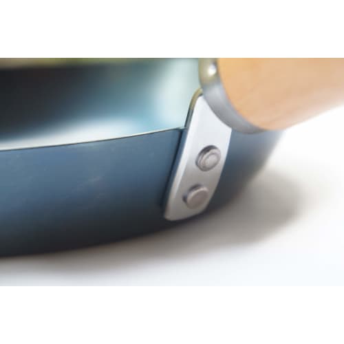 This 24cm iron skillet with a plain wood handle is made in Japan and is suitable for induction cooktops. It's lightweight and requires no seasoning. P