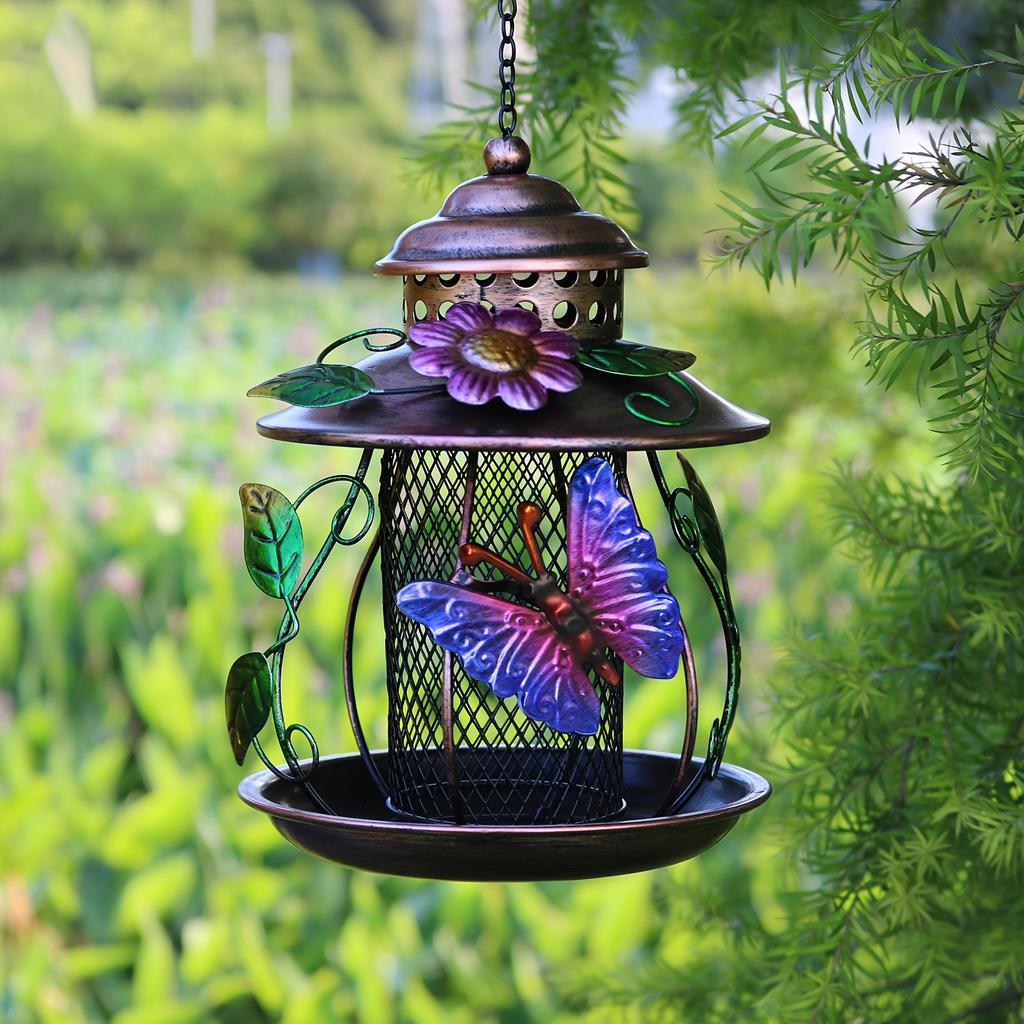 An outdoor hanging bird feeder with hooks and iron mesh, featuring decorative dragonfly and flower patterns, suitable for use in gardens or