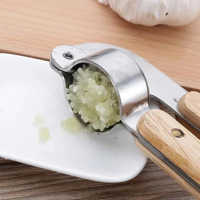 Nový 2024 Ruční lis na česnek s dřevěnou rukojetí Nerezová ocel 304 Drtič česneku Loupač česneku Drtič česneku Kreativní kuchyňské pomůcky1. Česnek