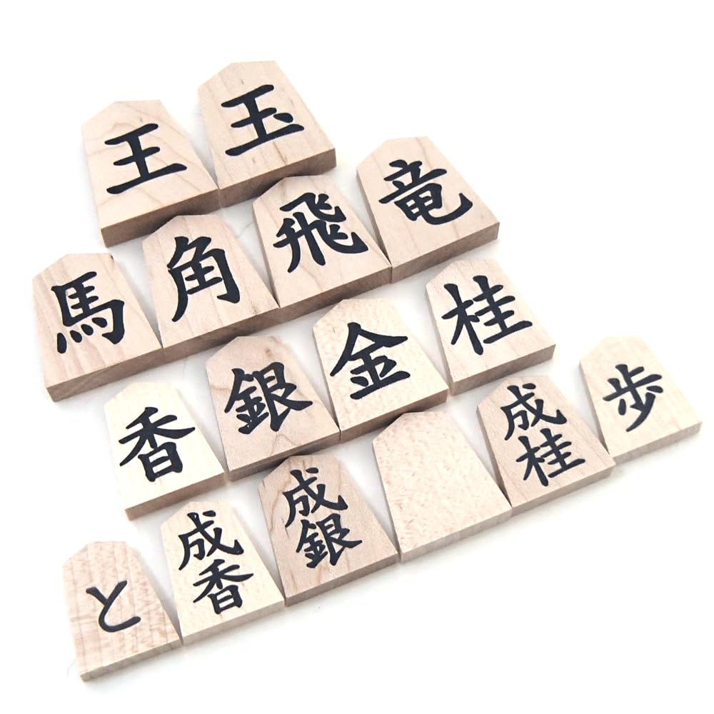 Wooden shogi pieces in regular script with a single maple character engraved on the back marked with black ink on the and presented in a paulownia