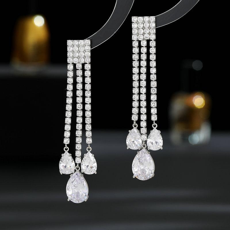 

Преувеличенные легкие роскошные серьги высокого класса, модное подиумное платье, свадебное платье с удлиненными модифицированными каплевидными серьгами с бахромой серебро белый