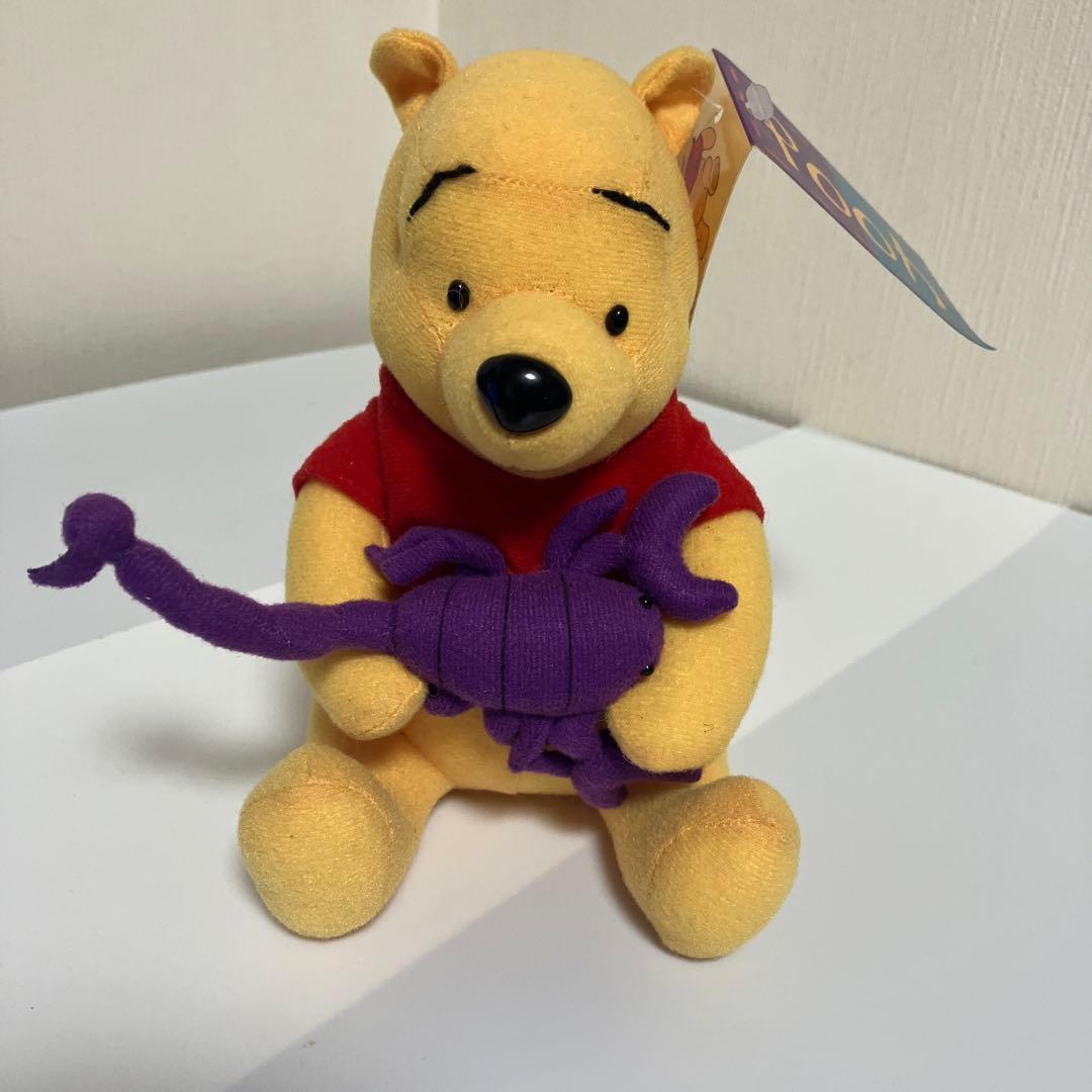 Winnie the Pooh stuffed animal with purple scorpion