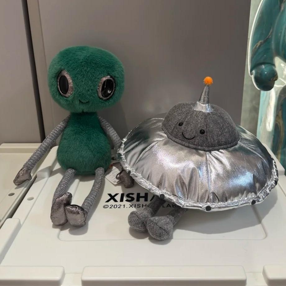 Peluche Espace Mignonne Alien Vert Souriant Soucoupe Volante Argentée Poupées Extraterrestres Douces Remplies Cadeau Adorable pour Fans de Science-Fiction Décoration de Maison