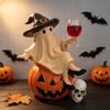 Halloween Ghost Sitting On A Pumpkin Figurine, Witch Holding A Red Wine Glass, Skeleton Decorating The Home Table for A Party Setup.