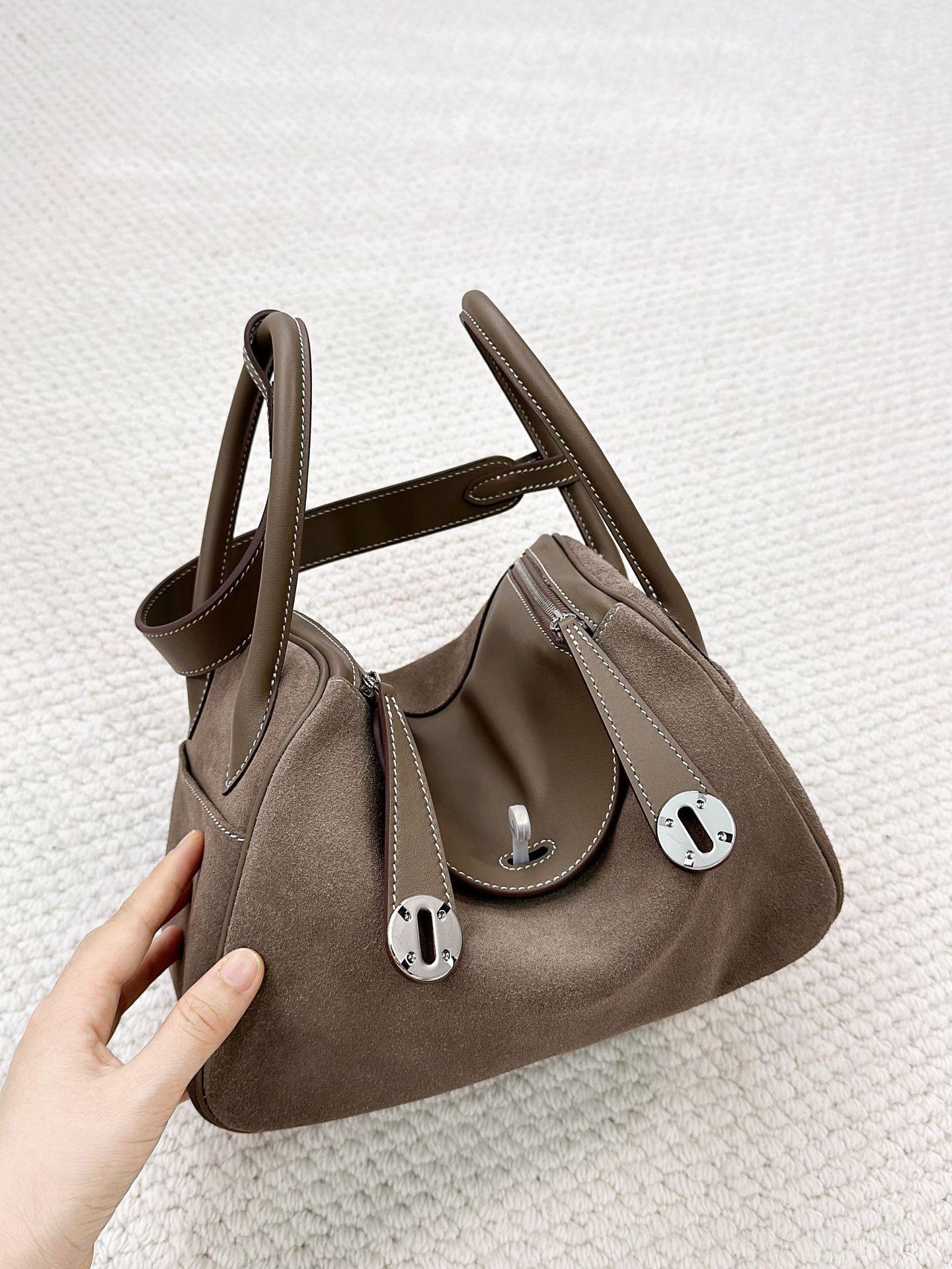 

Новая сумка из кожи swift и матовой замши для осени и зимы — это модная вместительная сумка-саквояж через плечо. 26x14x18cm серый