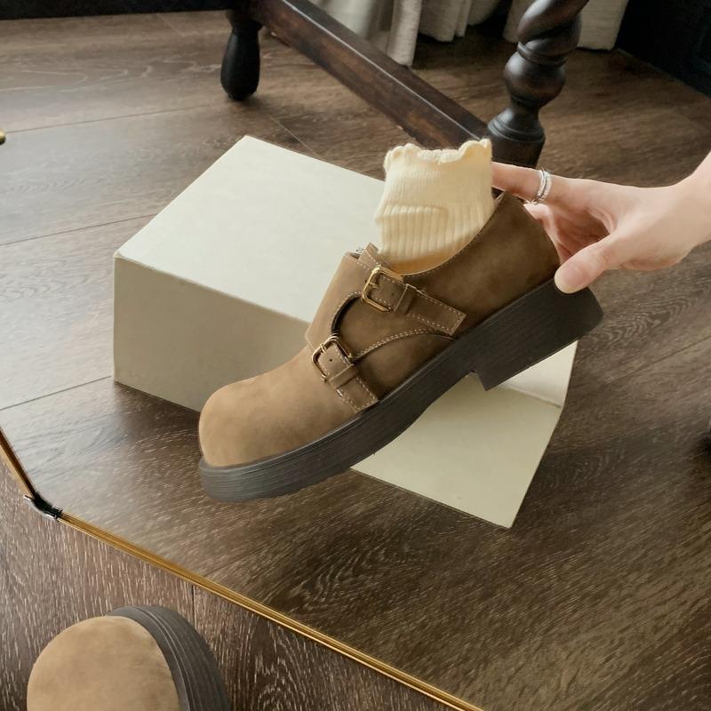 Eine Frau trägt ein Paar Retro-Schuhe mit großen Köpfen, runder Zehenpartie und rutschfesten Sohlen.