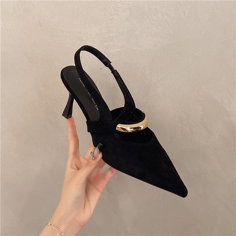 A Woman Wearing Half-slippers with An Inwardly Raised Metal Buckle Toe Cap and A Genuine Leather Pointed Toe on The Outside