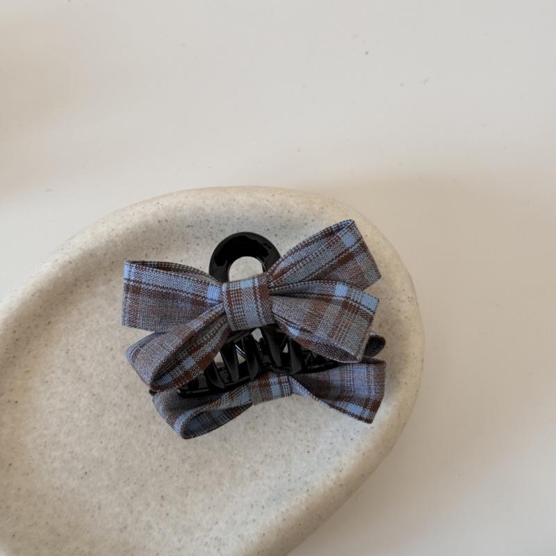 The Princess with The Checkered Bow Accessory Has A Chic Patterned Beak Hairpin At The Back of Her Head and A Hairclip.
