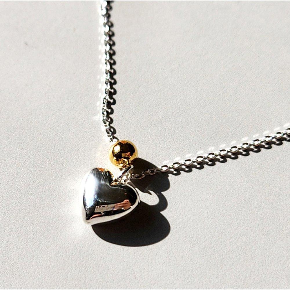 

Two-tone silver necklace with a heart ball
