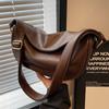 Eine Nischen-Retro-Achseltasche, eine modische Umhängetasche mit einem Riemen und eine weiche, hochwertige Knödeltasche