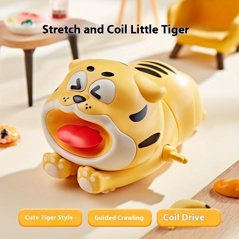 

Игрушечный тигр, лежащий на земле, ползает по полу. Милый мультяшный желтый тигр, заводная игрушка для детей.