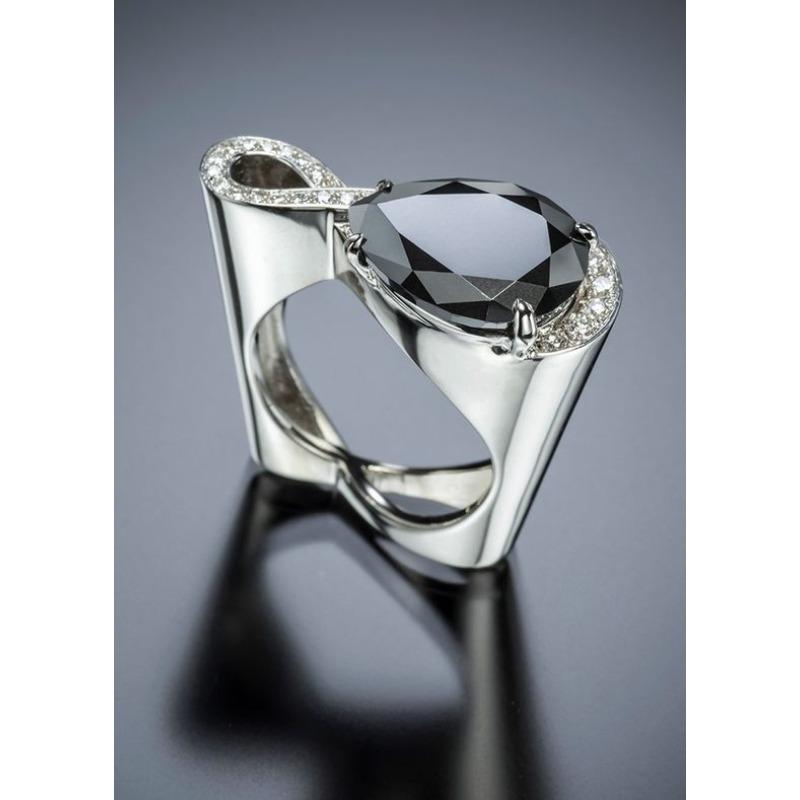 

This Unique Teardrop-Shaped Ring Features a Central Stone Resembling a Mysterious Dark Night Gem, Surrounded by Synthetic Stones Number 6