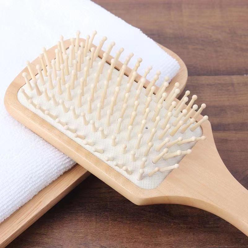 Spazzola a pagaia in legno antistatica per la cura dei capelli lunghi e il massaggio, riduce la caduta dei capelli e doma i ricci con design a cuscino.