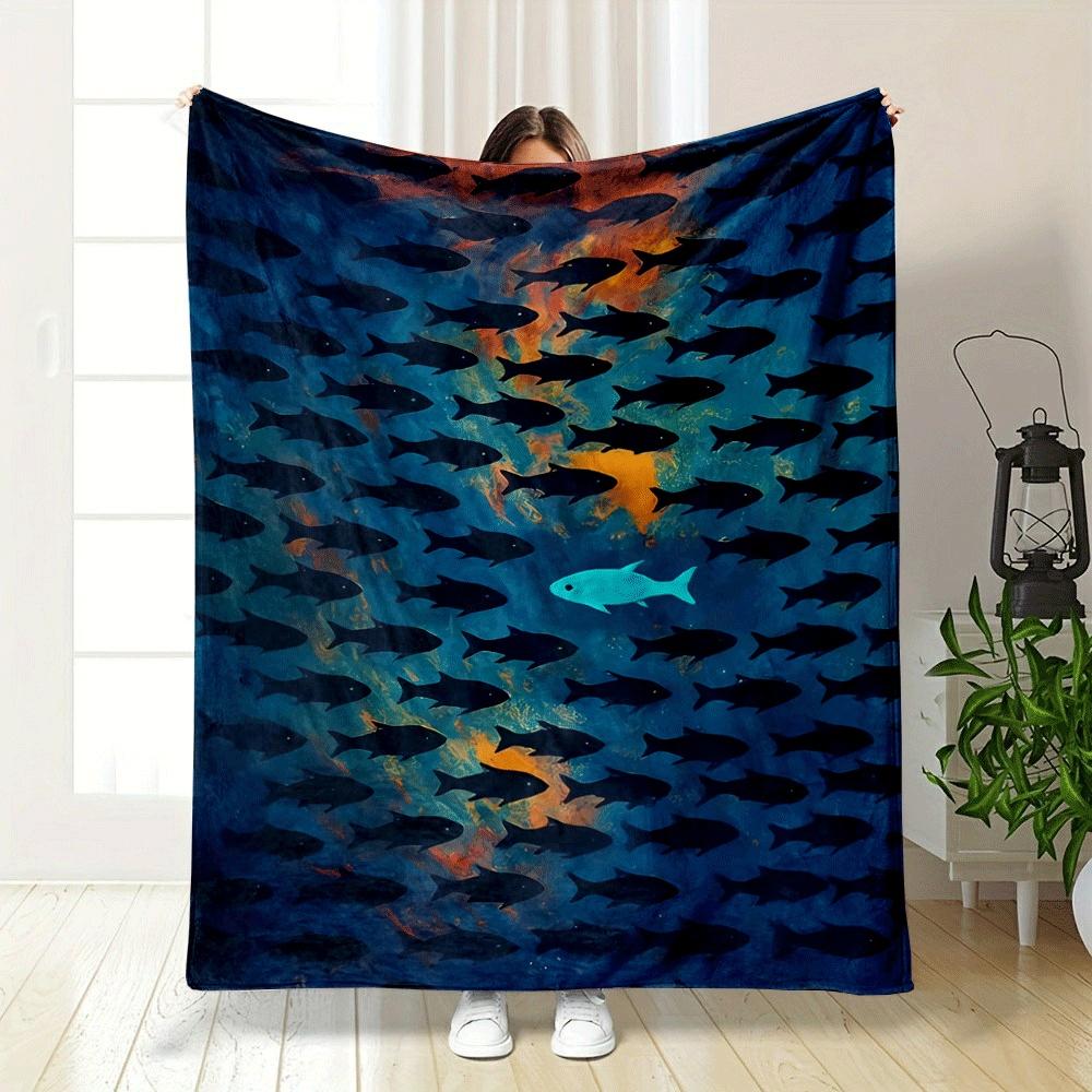 A lone bright fish swims opposite a school of dark fish on a vivid background. for all seasons blanket lunch break throw gift
