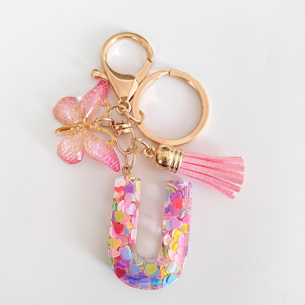 Rosa Glitzer Epoxidharz Schlüsselanhänger mit englischem Buchstaben und Schmetterlingsquaste