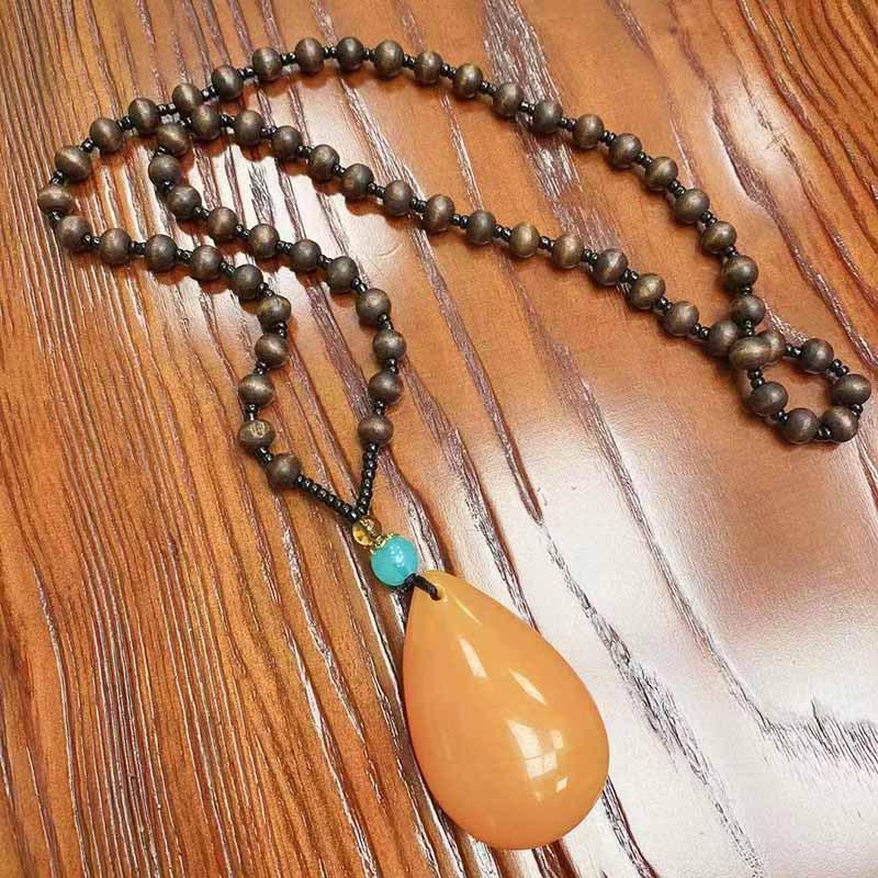 

Іву прикраси Етнічний стиль Імітація бджолиного воску Підвіска-крапля Серцевина з дерев яних намистин Довгий ланцюжок для светра Жіночий підвіска з імітацією бурштину