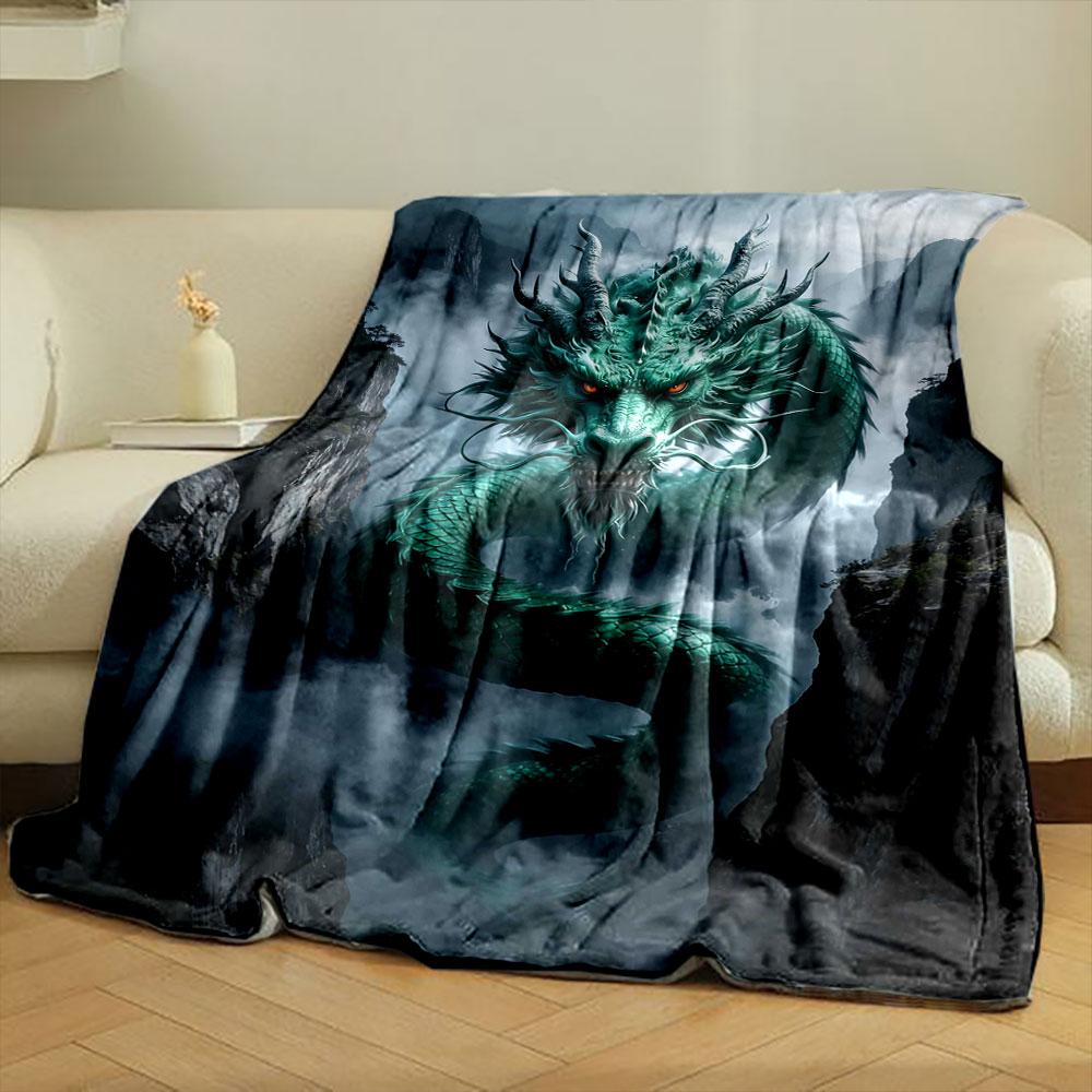 A green, serpentine dragon with glowing eyes emerges amidst misty cliffs. for all seasons blanket lunch break throw gift
