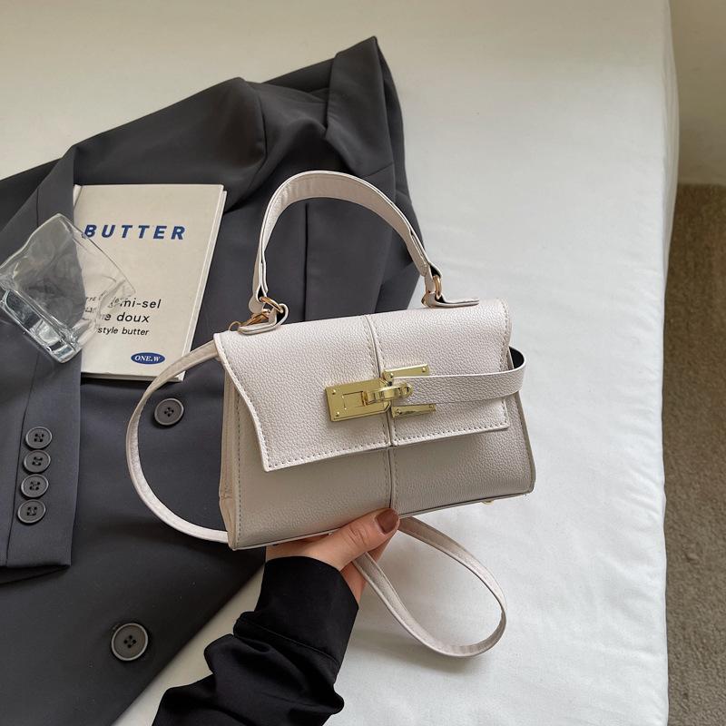 

New trapezoidal bag design exquisite lock bag high fashion shoulder handbag crossbody women s bag брудно-білий