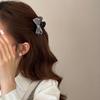 The Princess with The Checkered Bow Accessory Has A Chic Patterned Beak Hairpin At The Back of Her Head and A Hairclip.