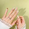 Trendy Handmade Nail Art: Nude Color with Floral and Rhinestone Accents for a Fashionable, Enhanced Look