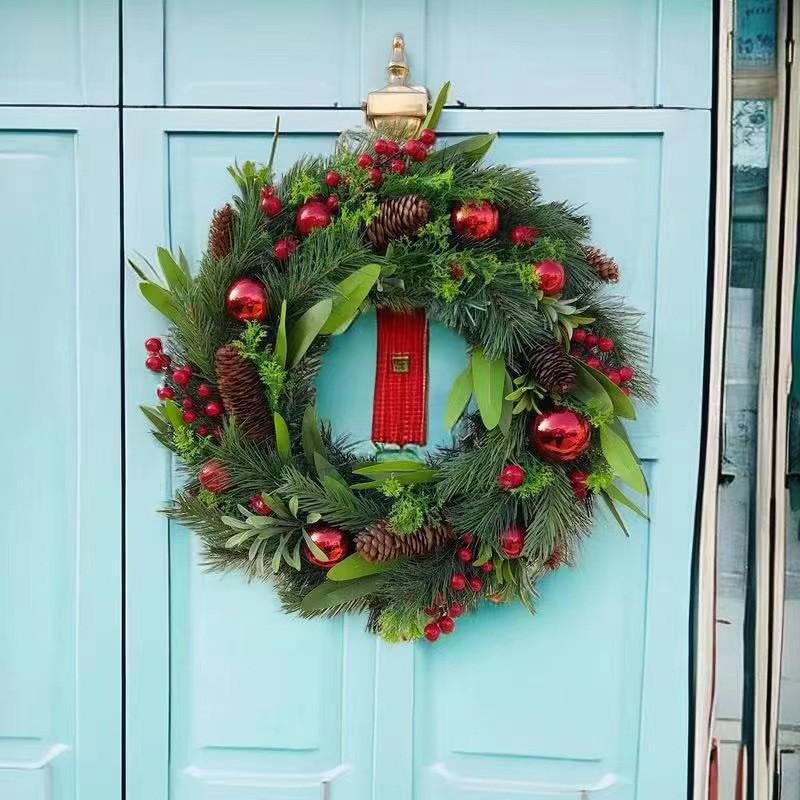 Grenzüberschreitender Weihnachtskranz aus Tannenzapfen und Beeren als Türschmuck