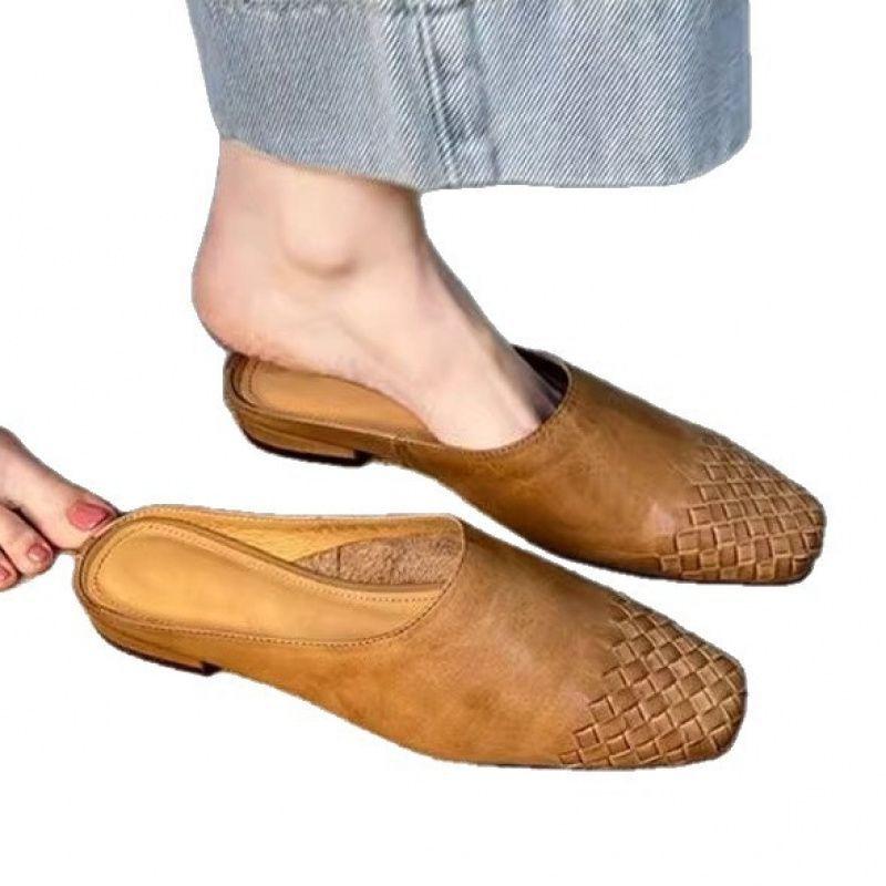 Eine Lammfellversion des französischen Retro-Webstirnbands Halbslippers, die eine modische und faule Frau draußen mit einem Fuß tragen kann.