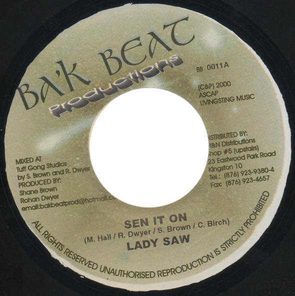 

7-дюймовая пластинка LADY SAW / CEMENT KIDD - Sen It On / Shake It BB0014 Ba k Beat Produ 2000 Ямайка Регги, Ска и Даб Б/у