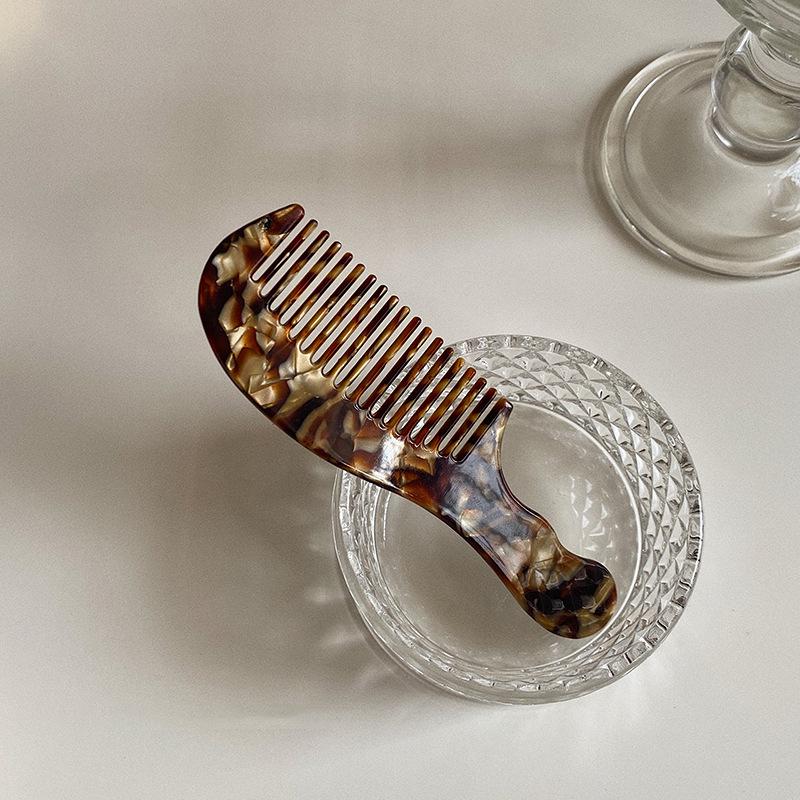 Elegant and compact tortoise shell acetate hair comb for easy portability.