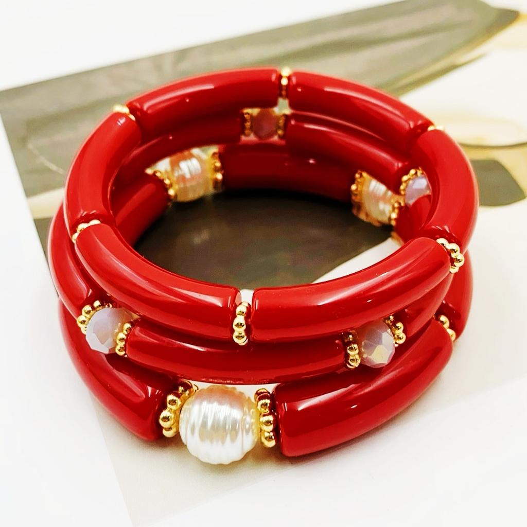 A set of three acrylic tubes connected by small golden flowers, adorned with crystal and faux pearl decorations, suitable for a lady's party.