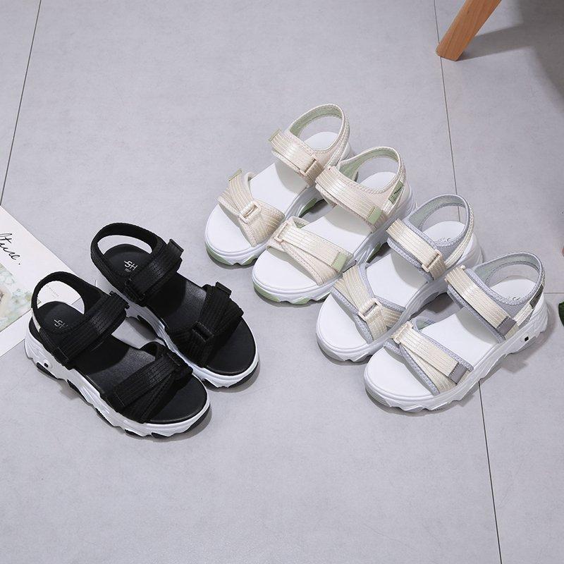 Dívky nosí malé vonné sandály s plochou a tlustou spodní částí, sportovní sandály, elegantní a pohodlné dámské módní boty