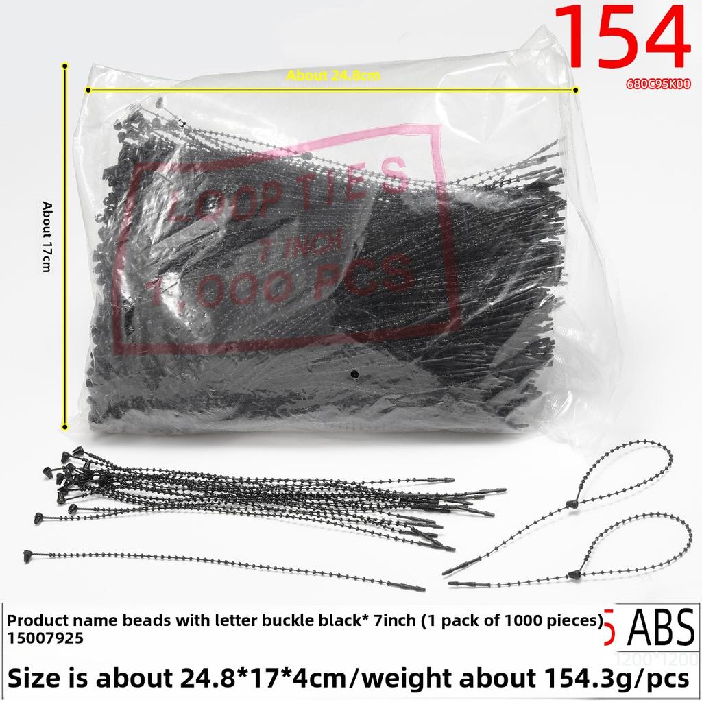 Schwarzes handgenähtes Fadenetikett mit einem Perlengarn, einer Gumminadel und Fadenetikett