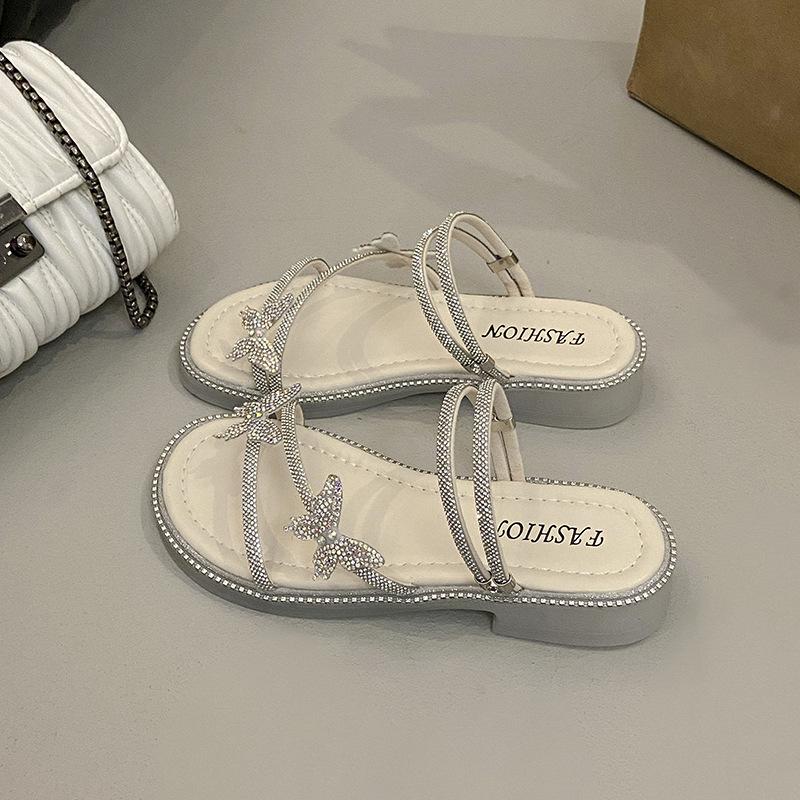 Beautiful slippers female 2025 summer wear new Internet celebrity butterfly rhinestone one-word drag fairy wind beach two sandals