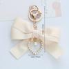 Elegant Pearl Strand Bow Keychain with Heart Charm, Octagonal Shape, Floating Fun-Themed Accessory, with Split Ring Closure for Handbags and Car Keys
