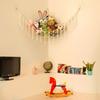 Toy hammock is hung in the corner and is equipped with a storage net, a toy storage bag, and a wall-mounted hammock.