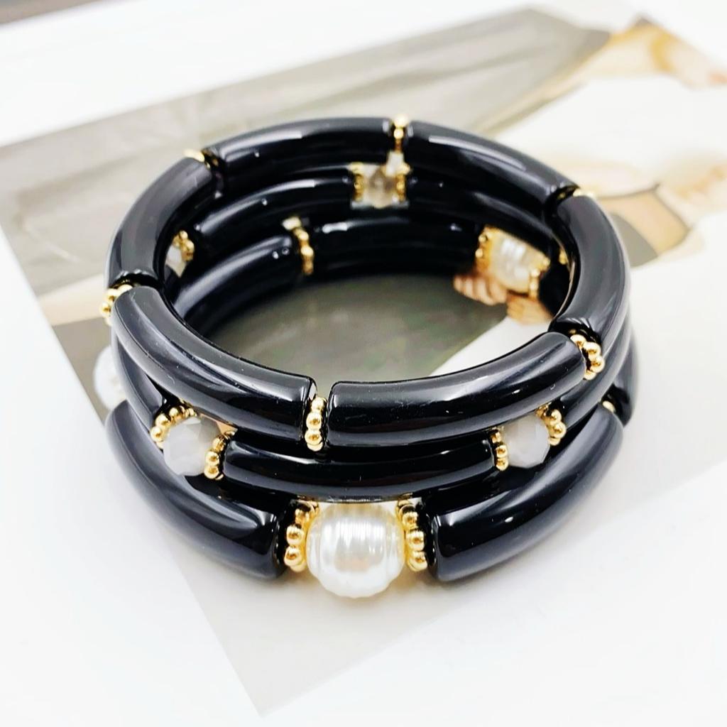 A set of three acrylic tubes connected by small golden flowers, adorned with crystal and faux pearl decorations, suitable for a lady's party.