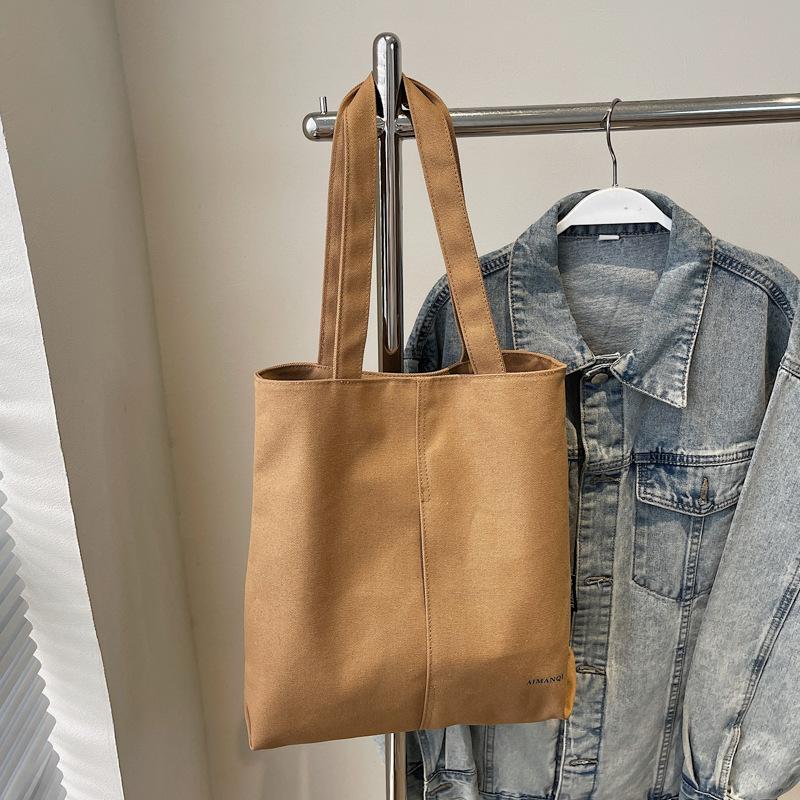 Eine modische und schlichte Umhängetasche aus Stoff mit großem Fassungsvermögen für Pendler-Studenten