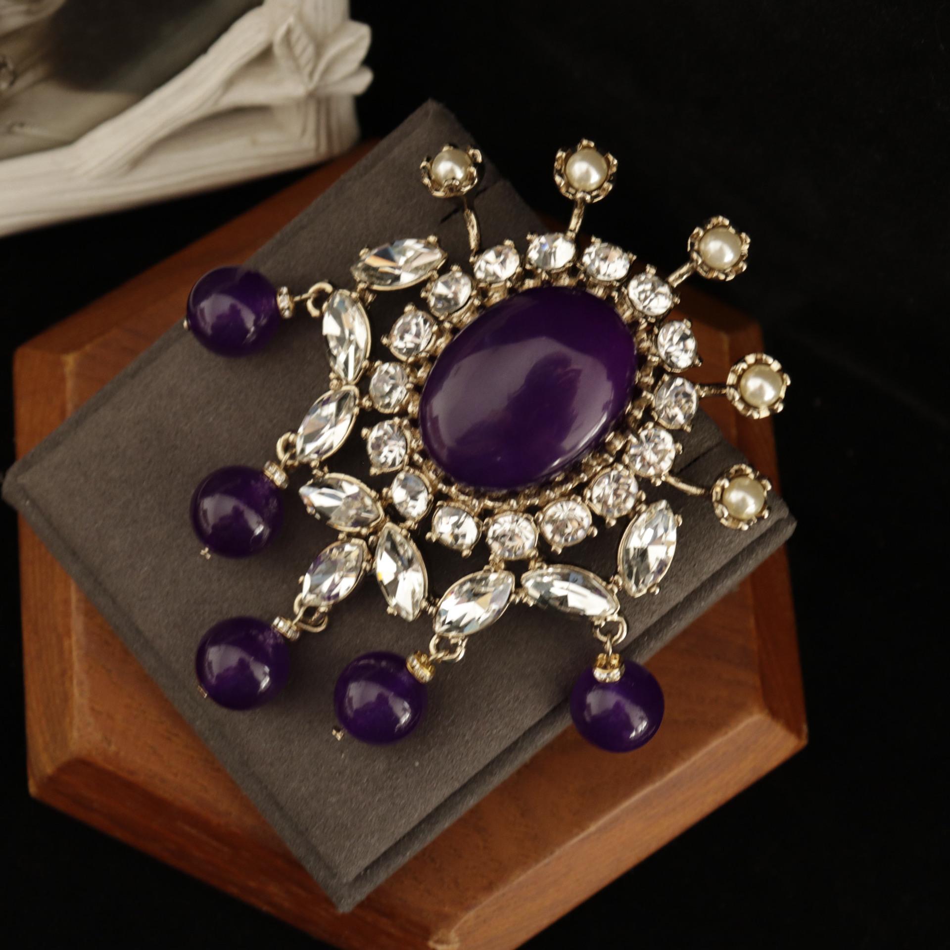 

Винтажная брошь в придворном стиле с фиолетовым камнем и роскошный комплект серег, достающих до плеч