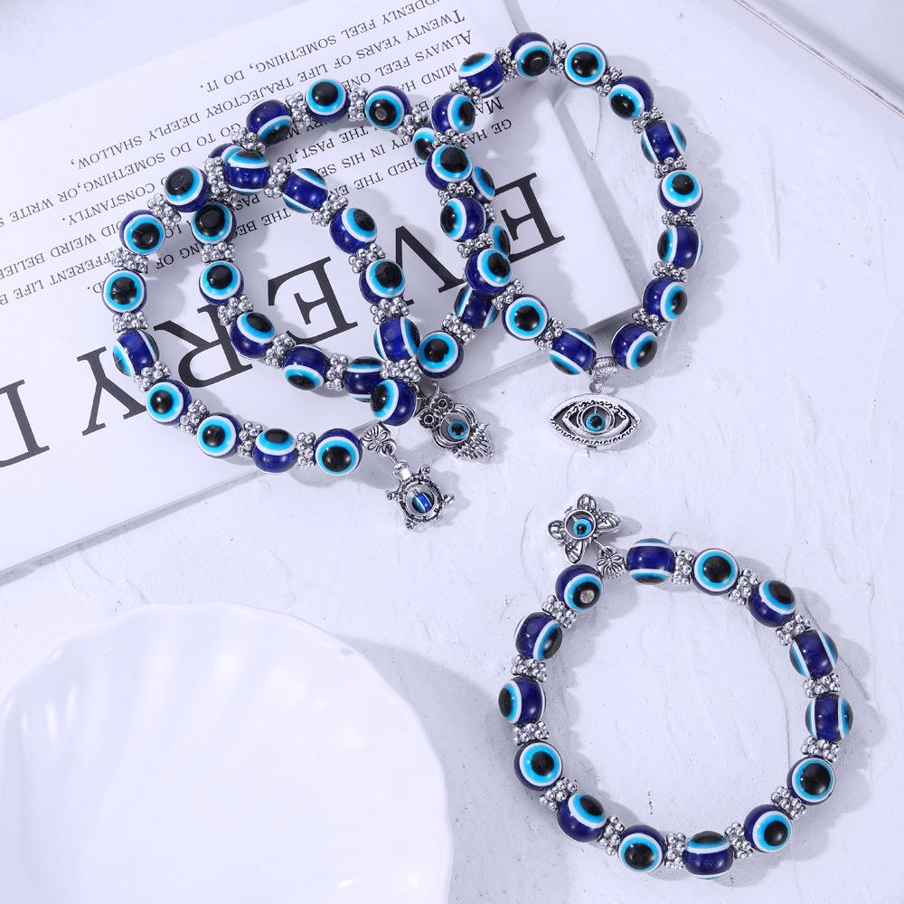 Beliebtes blaues Nazar-Armband mit Schmetterling-, Elefanten-, Fatimas Hand-Anhängern & Harzperlen