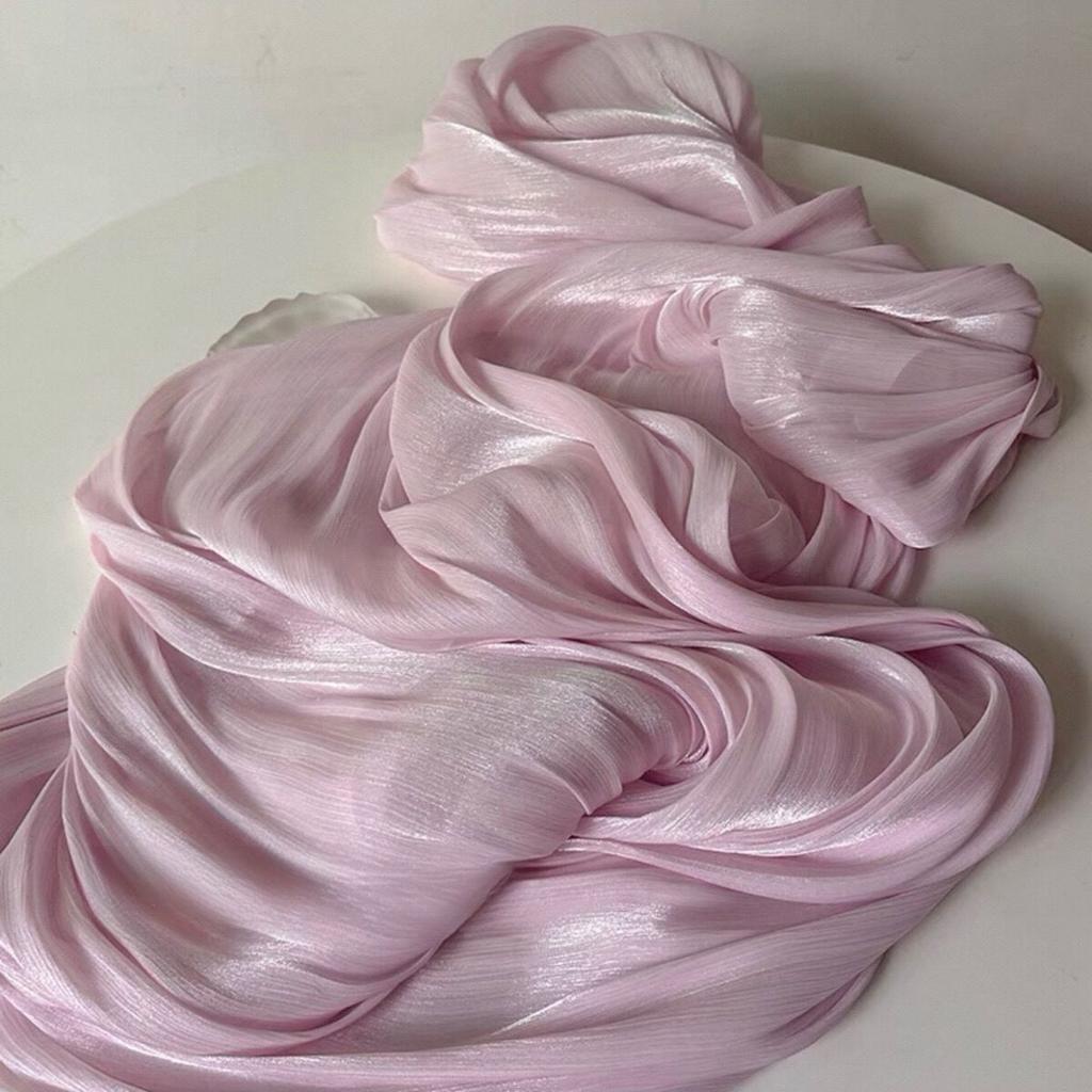 Soft shiny creased organza fabric with a smooth texture suitable for wedding dresses formal gowns and designer clothing fabrics