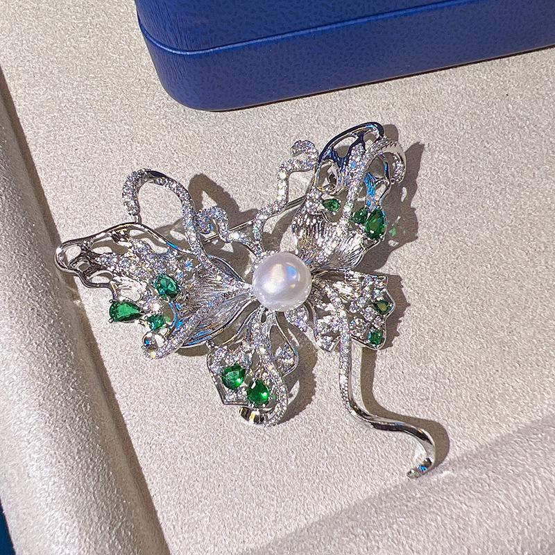 

Брошь-бабочка «Изумрудная лента» с позолотой из меди, цирконами и жемчужной вставкой для женщин