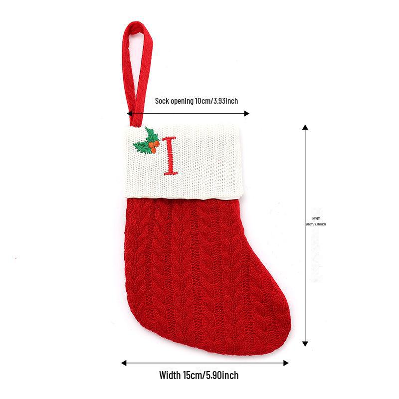 Weihnachtsdekorationen: Rote gestrickte Kinderstrümpfe mit gestickten Buchstaben