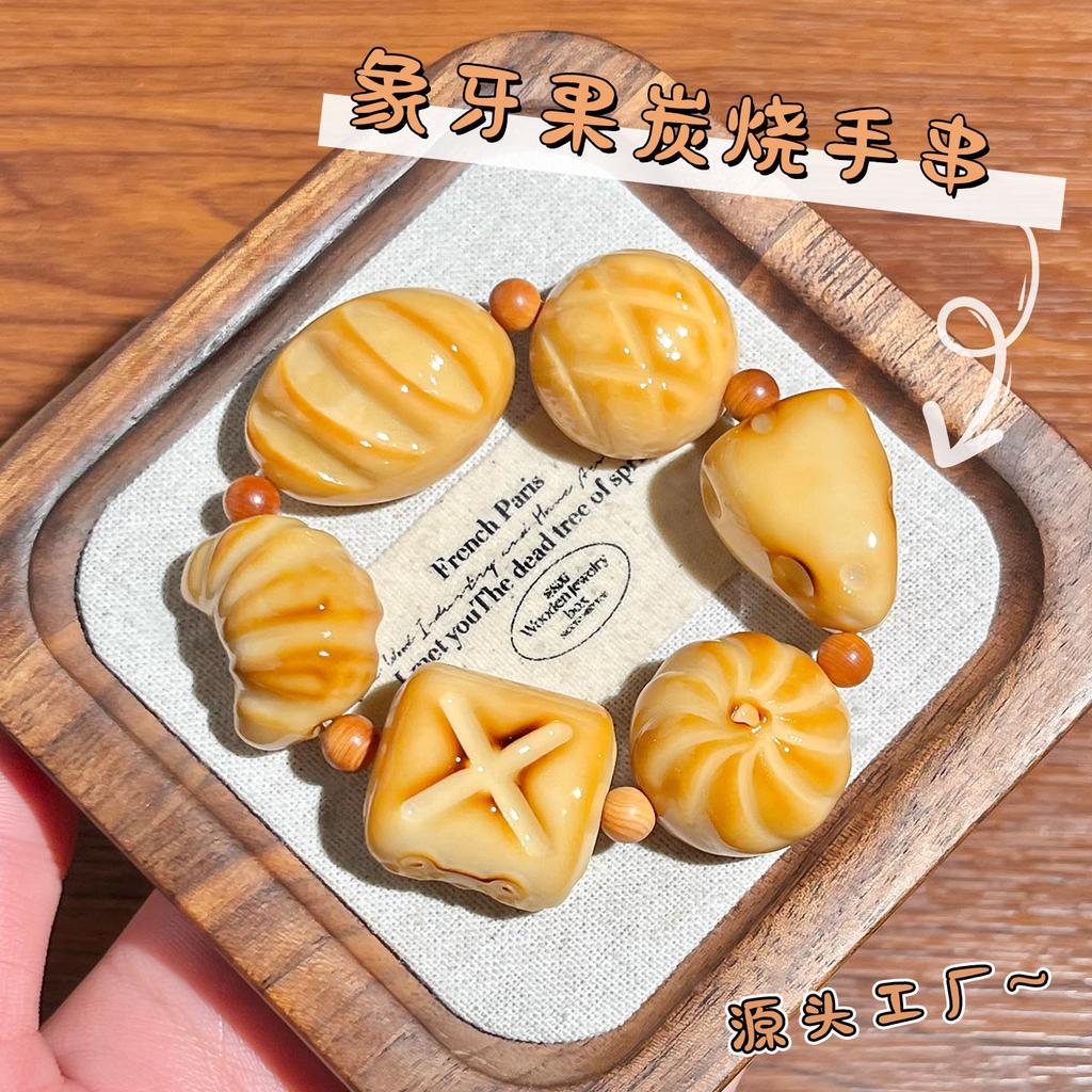 Der gleiche Stil wie der Little Red Shop: Holzkohle-gebranntes Elfenbein-Fruchtschnitzerei-Armband, süßes brotförmiges Elfenbein-Frucht-Kulturspielzeug-Armband für
