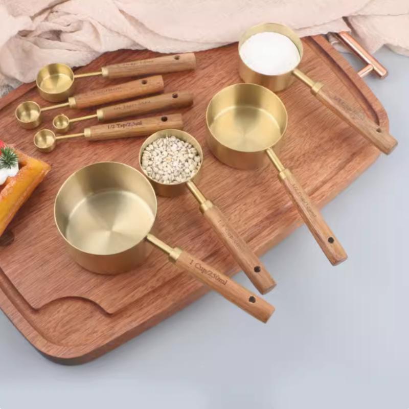 A Set of Eight Stainless Steel Measuring Cups and Wooden Handled Spoons for Kitchen Baking Tools, Measuring Tools, and Scales