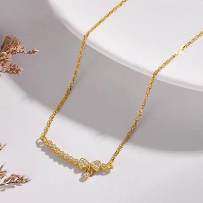 Lachende Damen-Halskette mit goldenem Schleifenanhänger an einer leichten Luxus-Schlüsselbein-Kette und einem Anhänger aus Imitationsgold